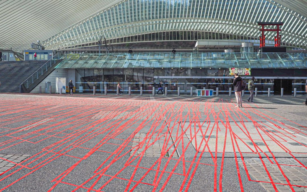 Des dizaines de mètres de ruban adhésif rouge collés par terre devant la gare des Guillemins